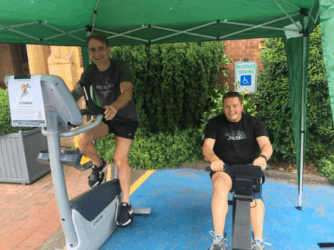 two men riding on exercise bikes