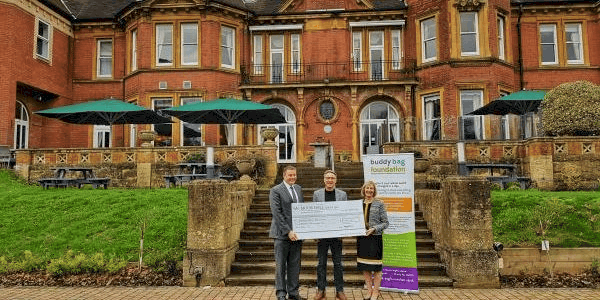 people in front of Moor Hall holding an oversized cheque