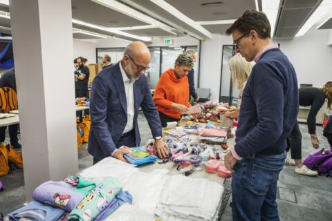 People packing items into a rucksack which are given to children entering emergency care in the UK.